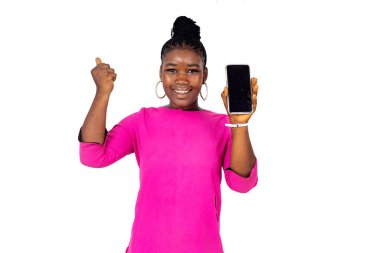 Pembe paçalı genç bir kız beyaz bir arka planda duruyor ve gülüyor..