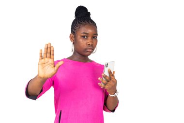  Gecelik giymiş genç bir kız beyaz bir arka planda durup gülerken ellerini uzatıyor..