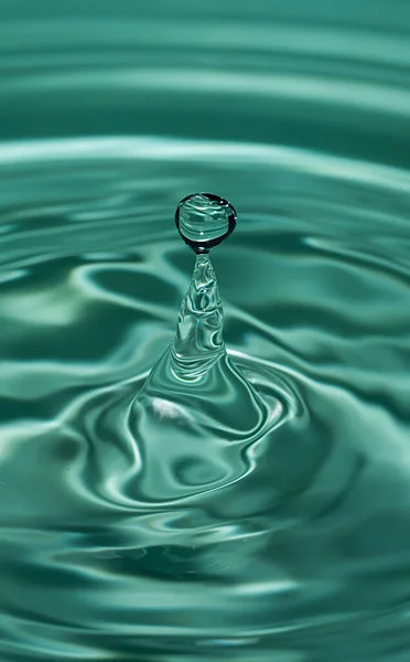 Circles on the water from a fallen drop of water. Blue, aquamarine background. High quality photo