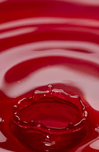 stock image Photo of circles on the water from a falling drop of water. Red abstract background. High quality photo