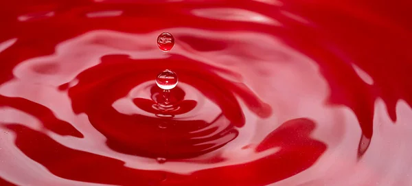 stock image Circles on the water from a falling drop of water. Red abstract background. High quality photo