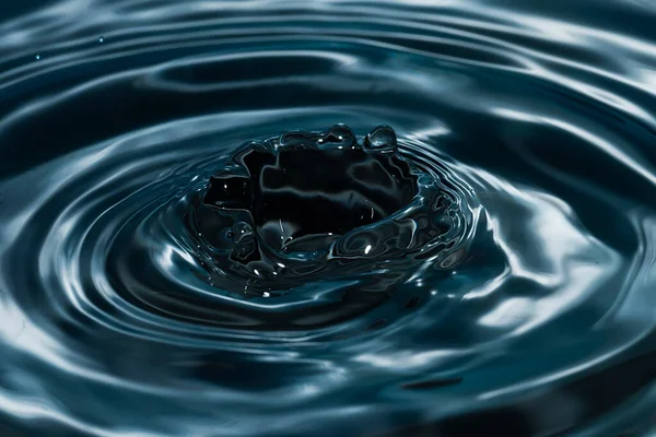 Cirklar Vattnet Från Fallen Droppe Vatten Mörkblå Bakgrund Högkvalitativt Foto — Stockfoto
