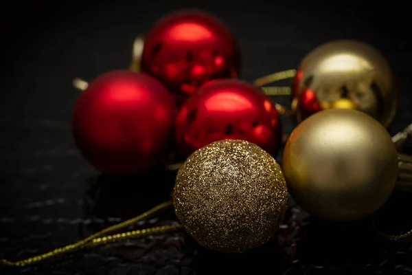 Christmas balls of red and gold color on a black background. Christmas background, screensaver. High quality photo