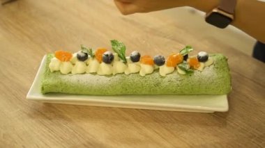 Fıstıklı çöreğe pudra şekeri serpiştiren kadın elleri. Pişirme ustası sınıfı. Yüksek kaliteli FullHD görüntüler