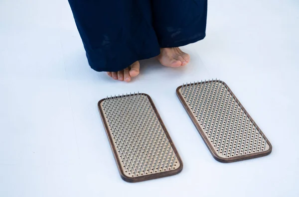 stock image The girl is preparing to stand on the board with nails. Nailing on boards of sadhus. High quality photo