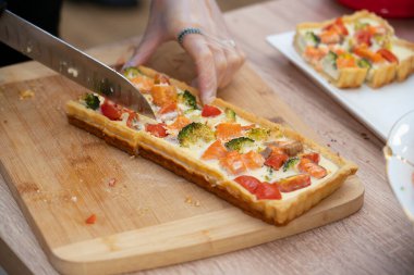 Yemek pişirmede mastır. Somon, brokoli ve domatesli kiş hazır. Yüksek kalite fotoğraf