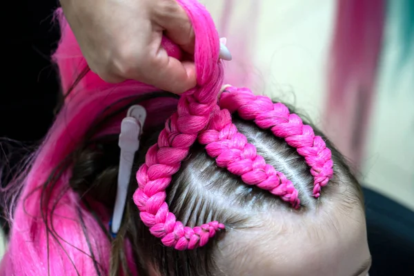stock image The process of braiding fashionable braids from bright pink and blue kanekalon for a girl. Back to school. Braid studio. High quality photo