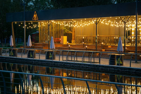 stock image Nursultan, Kazakhstan, August 2022. Street cafe lights reflected in a pond. High quality photo