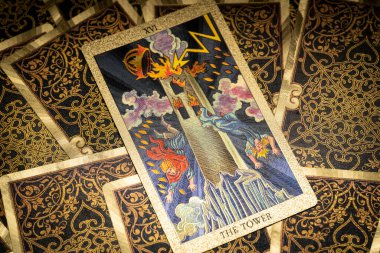 Masada altın işlemeli tarot kartları var. Binbaşı Arcana kartı. Kule izleyiciye bakıyor. Yüksek kalite fotoğraf