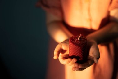 Kızın elleri, kalp şeklinde bir balmumu mumu tutuyor. Yüksek kalite fotoğraf