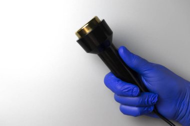 Mavi eldivenli bir el ultrasonik masaj için bir el yazısı tutar. Metin için yeri olan gri arkaplan. Yüksek kalite fotoğraf