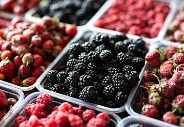 Bir sebze dükkanının tezgahında böğürtlen, ahududu ve çilek. Yüksek kalite fotoğraf