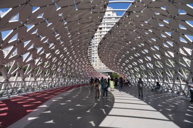 Nur-Sultan, KAZAKHSTAN - Temmuz 2021: Gökdelenler ve Ishim Nehri tarafında modern fütürist Atyrau köprüsüne sahip farklı ticari binalar. Yüksek kalite fotoğraf