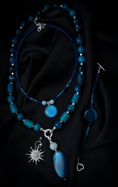 Doğal taşlardan, kolyelerden ve epoksi reçineden yapılmış bir kolye. Siyah arka planda agate 'den boncuklar ve kolyeler. Mücevherler. Yüksek kalite fotoğraf