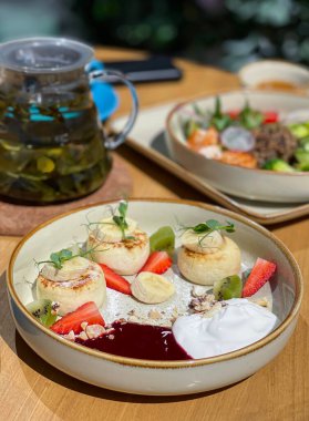 Reçelli, ekşi kremalı ve çilekli peynirli kek. Bir sokak kafesinde kahvaltı. Yüksek kalite fotoğraf