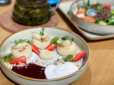 Reçelli, ekşi kremalı ve çilekli peynirli kek. Bir sokak kafesinde kahvaltı. Yüksek kalite fotoğraf