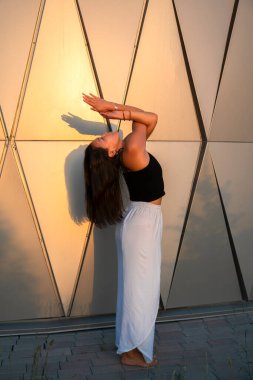 Genç Asyalı kadın gündüz vakti şehir manzarasıyla yoga yapıyor. Şehir yogası, gün doğumu egzersizi. Şehir yogası, gün doğumu egzersizi..