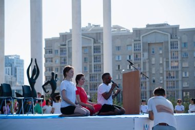 Astana, Kazakistan, 06.17.2023. Uluslararası yoga gününü başkentin karesinde kutluyoruz. Yoga hocaları nefes egzersizinden bahseder. Yüksek kalite fotoğraf
