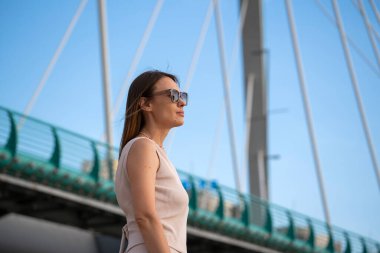 Mavi arka planda güneş gözlüklü esmer bir kadının yaz portresi. Yüksek kalite fotoğraf