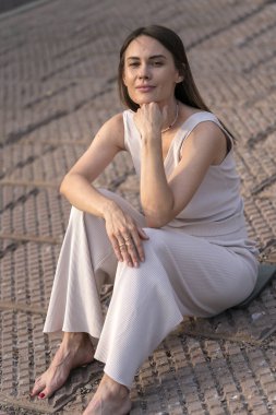 Genç bir kadının yaz şehir portresi. Bir kadın sette oturur ve bir şeyler düşünür. Yüksek kalite fotoğraf