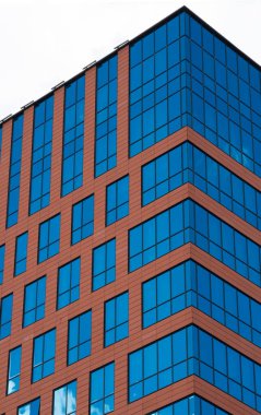 Gökyüzüne bakan mavi pencereli kahverengi bir gökdelen. Yüksek kalite fotoğraf