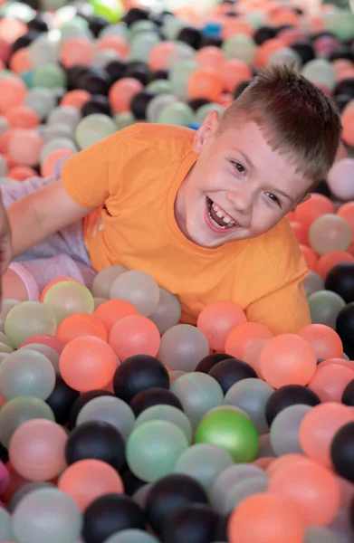 stock image Blond boy is having fun in the pool with plastic balls. High quality photo