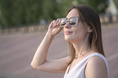 Güneş gözlüklü esmer bir kadının yaz şehir portresi. Yüksek kalite fotoğraf