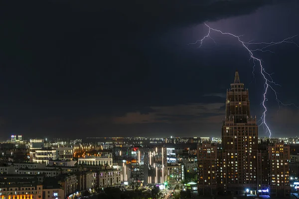 Astana, Kazakistan, Ağustos 2023. Başkentin merkez caddesindeki gökdelenin gece görüşü yıldırımlı bir fırtına sırasında. Yüksek kalite fotoğraf