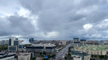 Astana 'nın merkez caddelerinden birinin görüntüsü. Bulutlar gökyüzünde hızla hareket eder. Astana, Kazakistan, Eylül 2023. Zaman atlamalı video. Tam HD görüntüler