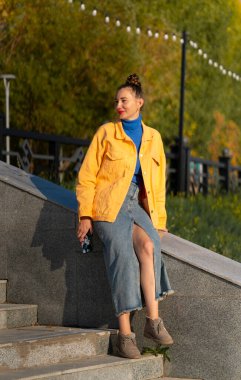 Genç bir kadın caddenin basamaklarında oturuyor. Yüksek kalite fotoğraf