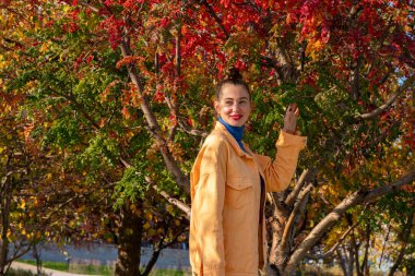 Sonbaharda parkta yürüyen genç bir kadın. Yüksek kalite fotoğraf