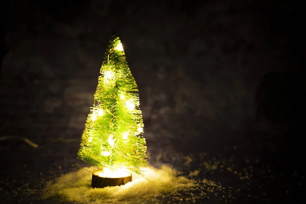 Yapay kar üzerindeki fenerlerle dekoratif Noel ağacı. Karanlık Noel arkaplanı ve mesaj yeri. Yüksek kalite fotoğraf