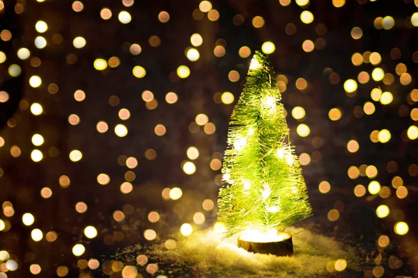 Yapay kar üzerindeki fenerlerle dekoratif Noel ağacı. Altın bokeh 'li karanlık bir Noel geçmişi var. Yüksek kalite fotoğraf