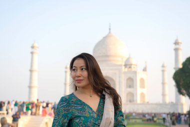 Agra, Hindistan, 23 Mart 2024. Arkasında Tac Mahal olan Asyalı bir kadının portresi. Yüksek kalite fotoğraf