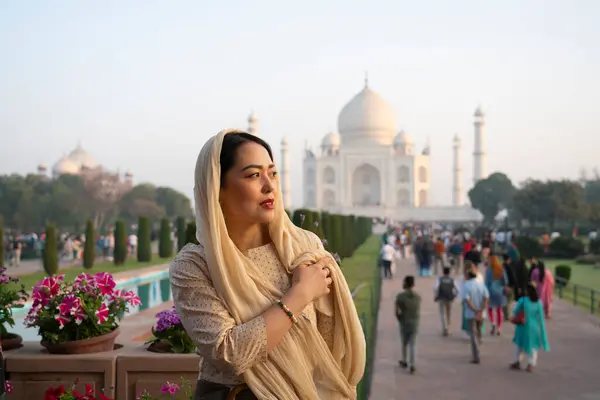 Agra, Hindistan, 23 Mart 2024. Arkasında Tac Mahal olan Asyalı bir kadının portresi. Yüksek kalite fotoğraf