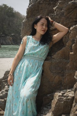 Bir kayanın arka planında mavi elbiseli bir kız. Rishikesh, Hindistan. Yüksek kalite fotoğraf