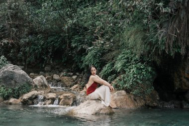 Hindistan, Gizli Şelale. Asyalı bir kız tropiklerin arka planına karşı. Çok kaliteli bir fotoğraf.