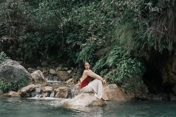 Hindistan, Gizli Şelale. Asyalı bir kız tropiklerin arka planına karşı. Çok kaliteli bir fotoğraf.