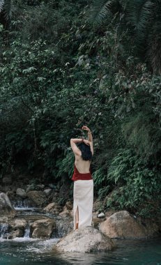 Hindistan, Gizli Şelale. Asyalı bir kız tropiklerin arka planına karşı. Çok kaliteli bir fotoğraf.