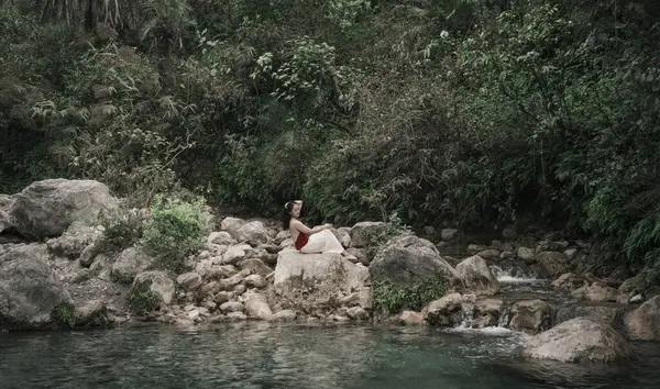 Hindistan, Gizli Şelale. Asyalı bir kız tropiklerin arka planına karşı. Çok kaliteli bir fotoğraf.