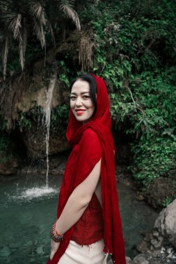  Gizli Şelale. Kafasında kırmızı eşarp olan Asyalı bir kız ormanda yaşıyor. Yüksek kalite fotoğraf