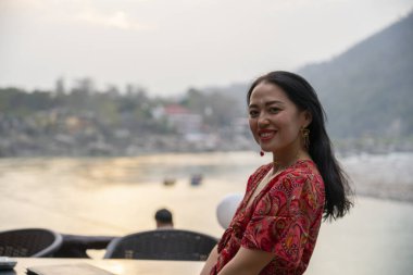 Rishikesh 'te arka planında Ganj olan Asyalı genç bir kadının portresi. Yüksek kalite fotoğraf