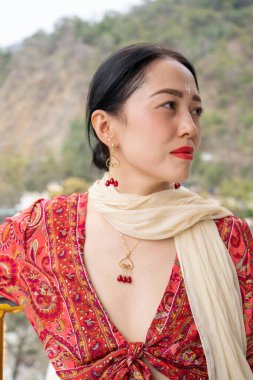 Kırmızı elbiseli Asyalı bir kıza takılı altın mücevherler. Yüksek kalite fotoğraf