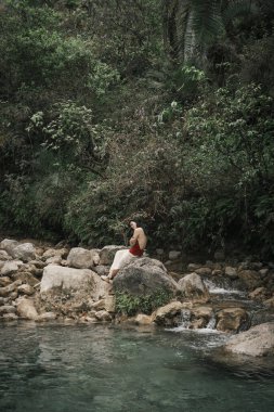 Hindistan, Gizli Şelale. Asyalı bir kız tropiklerin arka planına karşı. Çok kaliteli bir fotoğraf.