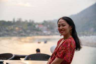Rishikesh 'te arka planında Ganj olan Asyalı genç bir kadının portresi. Yüksek kalite fotoğraf