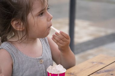 3 yaşında bir kız sokakta dondurma yiyor. - Ne? Yüksek kalite fotoğraf