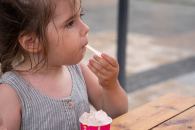 3 yaşında bir kız sokakta dondurma yiyor. - Ne? Yüksek kalite fotoğraf