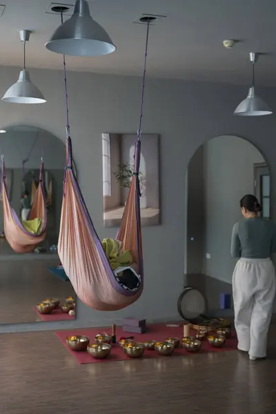 Bir kadın şarkı kâseleriyle ses terapisi yapıyor, insanlar yoga hamaklarında yalan söylüyor. Yüksek kalite fotoğraf