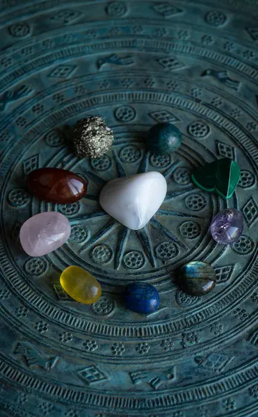 Kristaller, oyulmuş koyu mavi bir masa üzerinde yuvarlanmış doğal taşlar. Yüksek kalite fotoğraf