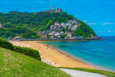 İnsanlar İspanya, San Sebastian 'daki Ondarreta plajında güneşli bir günün tadını çıkarıyorlar..